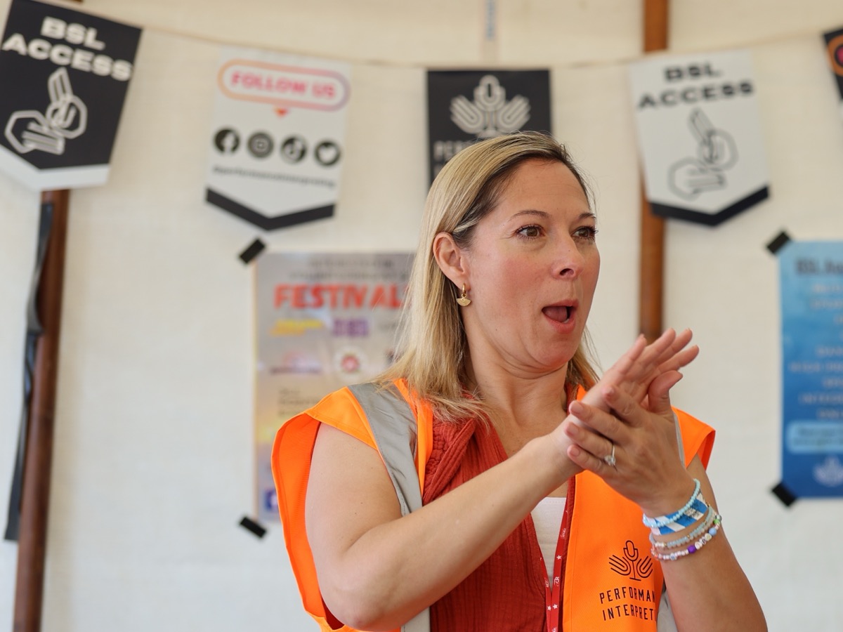 Marie Pascall signing at a festival BSL access tent